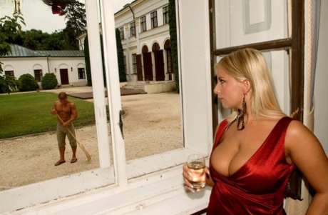 The hot MILF Lucy Love is dressed in a tight red dress, with her big tits being enjoyed outside.