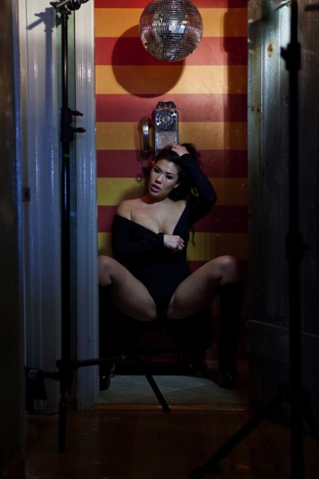 The Asian woman from London Keyes, who is a solo girl, displays her gestures by placing her hands near a payphone.