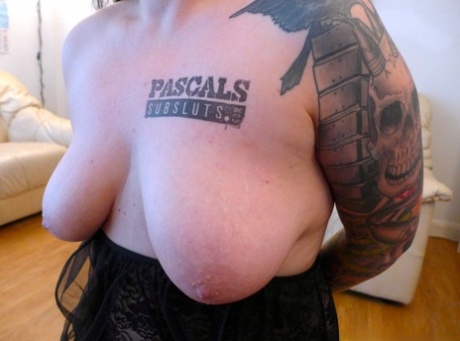 On a comfortable chair, Nikki Gold, a tattooed woman, performs stripping and oral sex on the tongue before engaging in sexual activity.