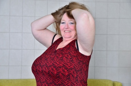 British woman BBW lets her saggy old breasts go free in mesh nylons and black boots.