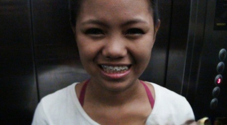 A young Asian girl wearing braces engages in PTM closeup action.