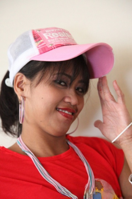 The Asian girl models her beaver in a T-shirt and ball cap.