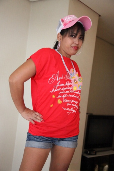 An Asian girl models herself as her beaver in a T-shirt and ball cap.