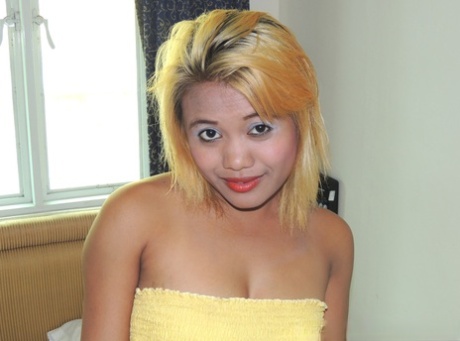 With her blonde hair on, Asian lady Ailyn poses with a naked pussy.