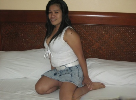 In a black thong, the chubby Filipina girl loosens her big naturals on a bed.