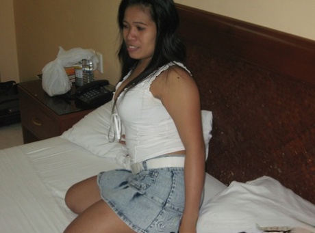 The chubby Filipina girl releases her big naturals on a bed covered in black thongs.