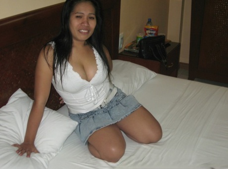 Chubby Filipina girl releases her big natural hair on a bed covered in black thongs.