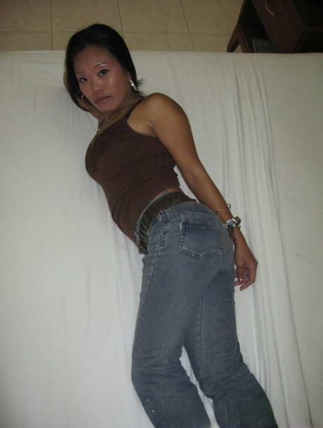 As she gets nude, a Filipina amateur slips on denim jeans and covers her thong-covered buttocks.