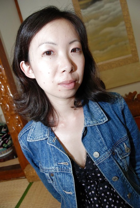 The Shy asian MILF engages in playful and sexual activities while stripping down.