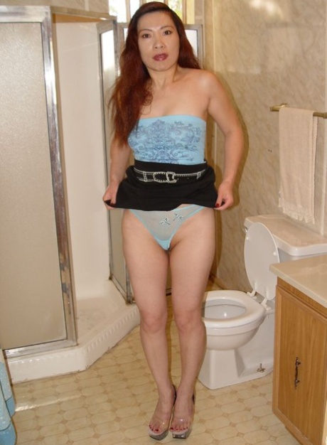 An unruly Thai woman with red hair urinating and cleaning up her neatly-tailored cocker.