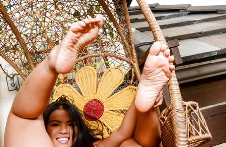 An unassuming Asiac female removes her clothing and displays a clean-cut fist to showcase her attractive feet and shaved head.