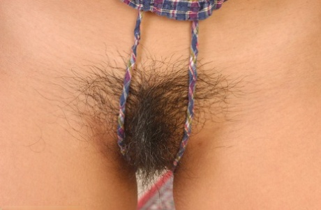 An Asian female with a charming appearance, including a sweet-looking face and small tits and hairy pussy strips, is an amateur.