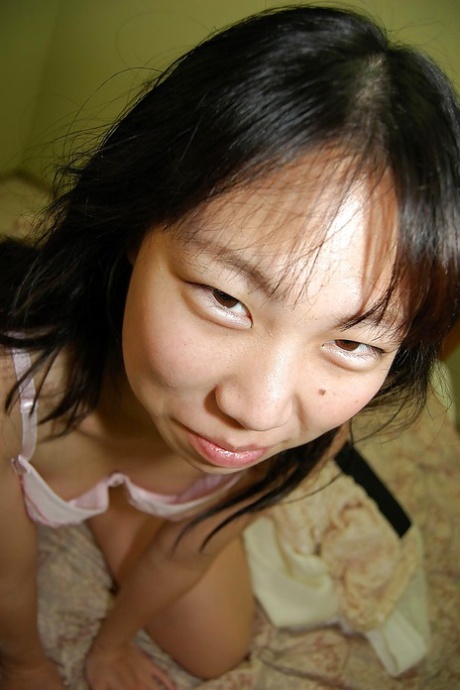 Cute little brunette Noriko undresses her hairy vagina.