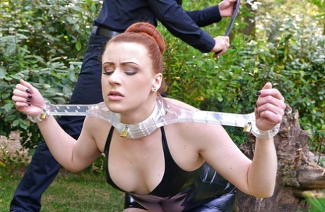 Outdoor scene: European redhead Isabel Dean takes part in an BDSM scene.