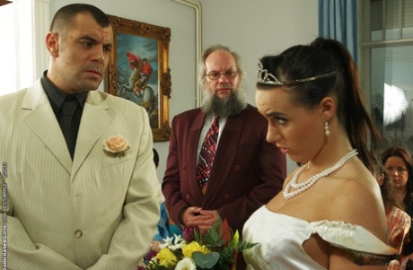 The dark-haired female, Wild Devil, takes pleasure in a BDSM act while wearing her wedding dress.