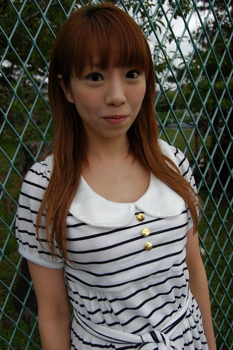 Asian Chihiro Ozawa is dressed in a provocative stripe dress while walking outside.