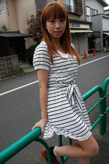 Chihiro Ozawa, an Asian, is seen walking in her striped dress for the day.