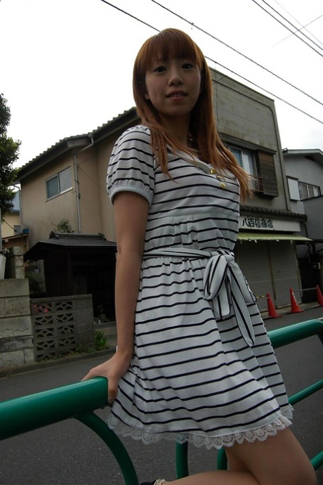 Chinese fashion icon Chihiro Ozawa is seen walking in her striped dress for a photo outside.