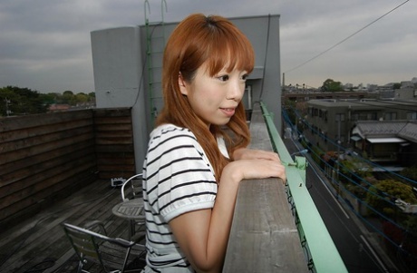 Chinese fashion trendsetter Chihiro Ozawa walks in her striped dress while wearing it outdoors.