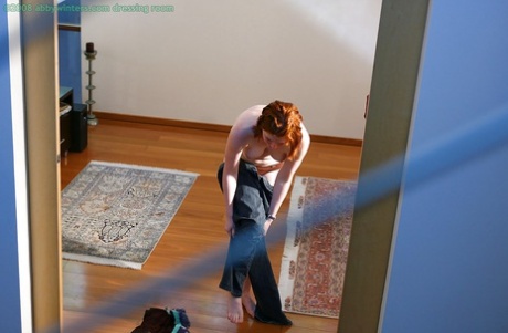 This is a hidden camera that captures the natural redhead pulling panties over their comfortable buttocks.