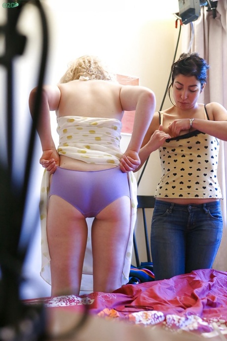 Two women are photographed by a spy camera as they dress up after having intercourse.