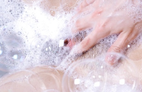 An Asian woman who is a first-timer experiences water and sweat in the bathtub with her hairy twat.