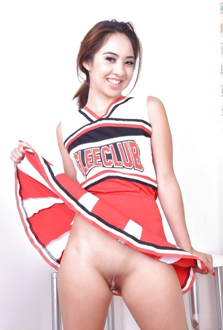 Mila Jade, an Asian amateur, exposing a smooth pussy beneath a cheerleader costume.