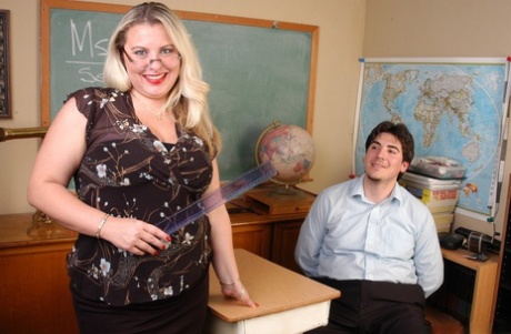 A fat blonde teacher named Tawni has a large pussy on her penis while in the classroom.