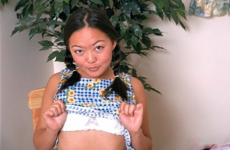 First time Asian, Amy stripped down to model on chair in pigtails for the first time.