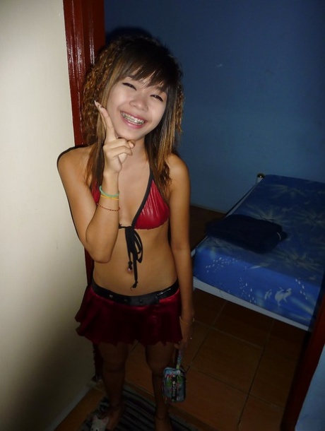 A tiny Thai bar girl named Ploy with a tight ass and pussy on her bed.