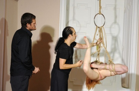 Two men engaged in redhead slaveing of Amarna Miller during BDSM sex games.