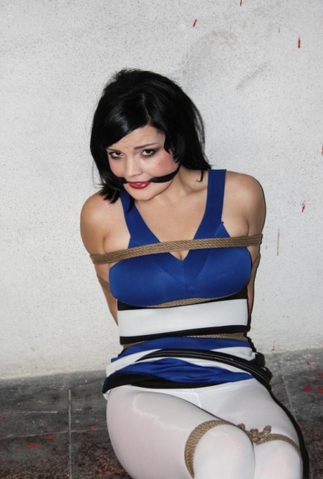 Rope bound and gagged leave the woman with dark hair helpless.