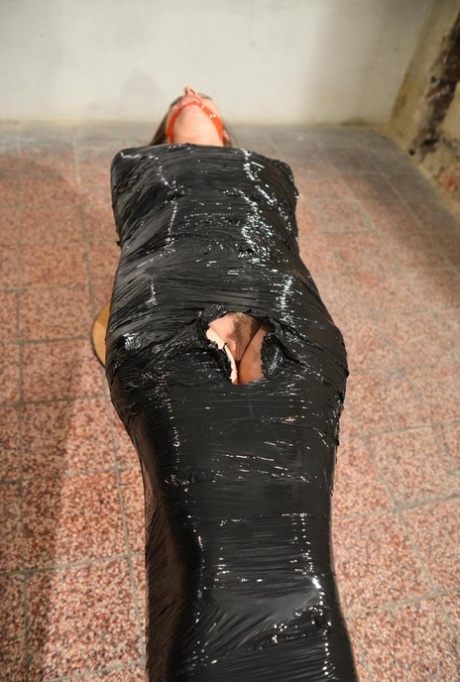 Only a naked woman wearing high-heeled shoes is petrified by plastic and looks gagged.