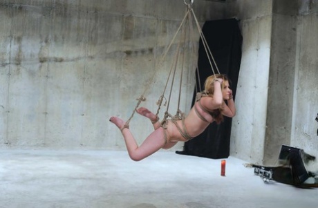 With hot wax and clothespins placed on her scalp, the woman who is suspended in pain cries out in agony.