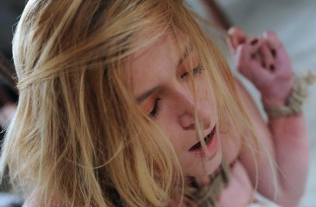 A female body is drenched in agony while being restrained with hot wax and clothespins.