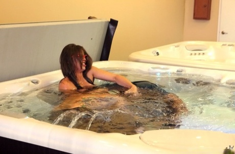 Uncommonly stripped naked, an amateur female participates in sex games in a hot tub.