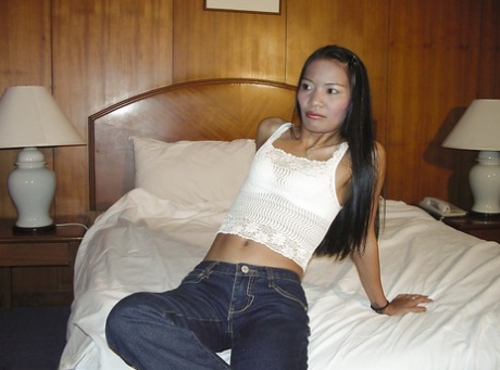 This is a cute looking, diminutive Asian babe who was playing with a dildo on the bed and stripping.