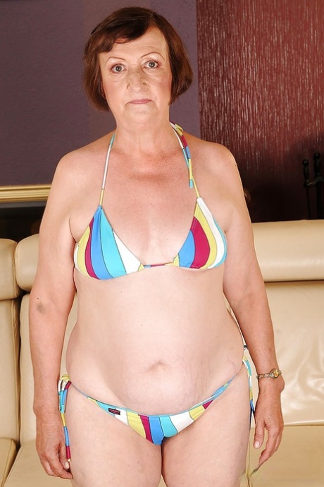 Eve Tickler, a fat granny with tiny tits, taking off her bikini.