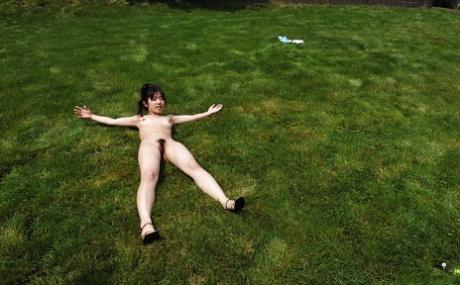 A charming Asian female in small tits, enjoying herself outside while posing for photos with her little hands exposed and naked.