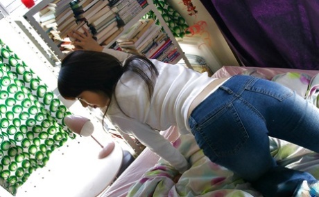 A slim, Asian female with a clean cut is undressing her clothes.