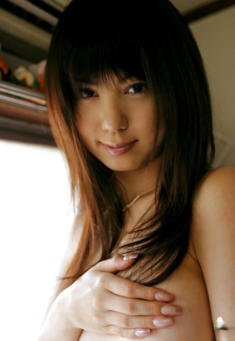 This Asian female is slim and has a well-defined but curvaceous body that's barely visible when she removes her clothes.