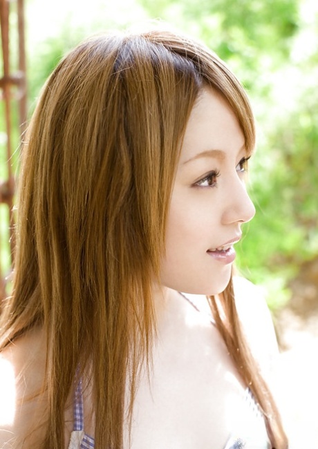 Ria Sakurai, a gorgeous Asian female beauty, flaunting her stunning figure outside.