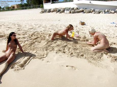 Teenage naked girls wearing sunglasses enjoying the sun on the beach.