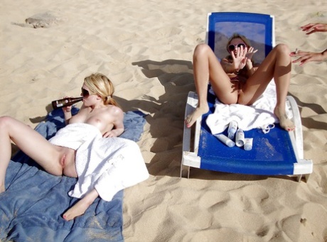 Teenager lesbians engaging in intimate acts while on the beach, stripping and fondling each other's genitalia.