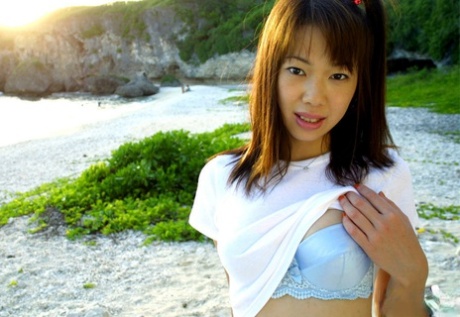 Weighed down, the thin Asian female named Hikari is seen in a skimpy white nighty attire outside.