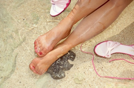 Wearing sun glasses, Roni dresses up as a young woman on the beach and sews up with nylon pantyhose.