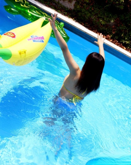 The hip, Asian girl enjoys her time in the pool and exposes her large jugs.