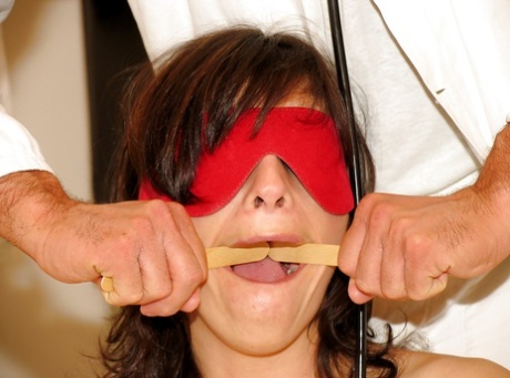 In the BDSM world, a MILF dressed in stockings and blindfolded enjoys an encounter with a masked man who is also wearing masks.