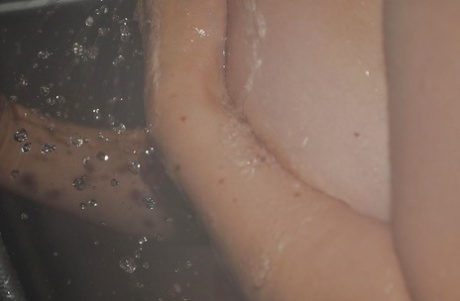 Chiho Fujii, a feeble-looking Asian MILF with flabby tits, taking a dip in the bathtub.