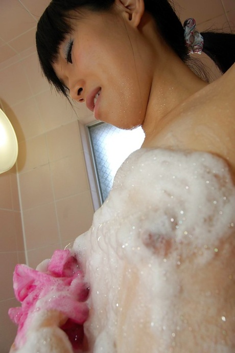 Chiharu Moriya, an Asian female with a well-groomed body, is bathing and caressing her delicate curves.